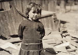 HINE: POOR GIRL, 1917. A poor girl standing with her arms behind her back in front HINE: POOR GIRL, 1917. A poor girl standing with her arms behind her back in front