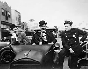 Comedy Gallery: LAUREL AND HARDY, 1928. Stan Laurel, left, and Oliver Hardy with a police officer in the silent