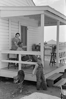 NEW HOME, 1938. Former tenant farmer and family on the front porch of their new home NEW HOME, 1938. Former tenant farmer and family on the front porch of their new home