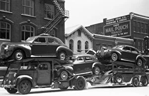 OHIO: AUTO TRANSPORT, 1940. A truck carrying automobiles through the streets of Chillicothe, Ohio