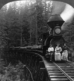 OREGON: LOGGING TRAIN. Two women and a man seated on front of logging train pulling flatcars loaded with huge logs