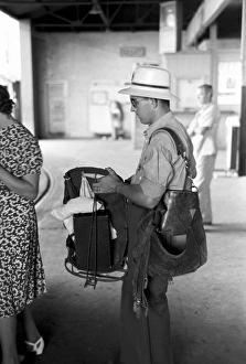 POSTMAN, 1939. A postman with equipment waiting to board a streetcar at the terminal POSTMAN, 1939. A postman with equipment waiting to board a streetcar at the terminal