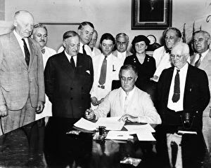 President Franklin D. Roosevelt signing the Social Security Act in the Cabinet Room of the White House, 14 August 1935