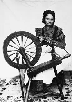 SPINNING WHEEL. An American woman spinning yarn. Photograph, 19th century