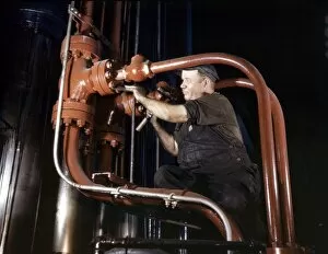 Denim Gallery: STEEL HYDRAULIC PRESS, 1942. Maintenance man working on a cold steel hydraulic