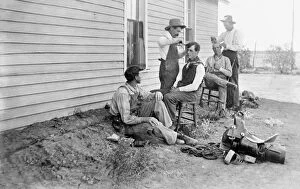 TEXAS: COWBOYS, c1908. Five cowboys outdoors with two of them getting haircuts