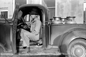 Pick Up Truck Gallery: TEXAS: CREAMERY, 1939. A man waiting to unload milk cans filled with raw milk at