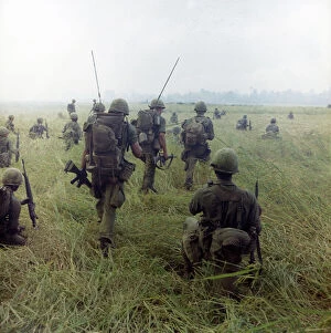 Helmet Collection: VIETNAM WAR, 1966. Members of the 101st Airborne Division moving across a rice