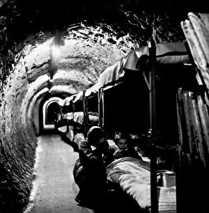 Images Dated 8th June 2012: WORLD WAR II: BOMB SHELTER. A woman kneeling beside a girl in a bunk bed in a bomb shelter located