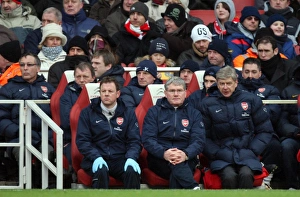 Arsene Wenger the Arsenal Manager sits on the bench with Pat Rice (Assistant Manager) Arsene Wenger the Arsenal Manager sits on the bench with Pat Rice (Assistant Manager)