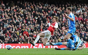 Nicklas Bendtner is tripped by Huddersfield defender Jamie McCombe for thre Arsenal Nicklas Bendtner is tripped by Huddersfield defender Jamie McCombe for thre Arsenal
