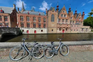 Bicycles leaning against a canal wall with medievel buildings, Bruges, Belgium