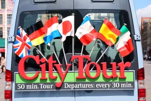 Sign with international flags on a City Tour sightseeing bus, Bruges, Belgium Sign with international flags on a City Tour sightseeing bus, Bruges, Belgium