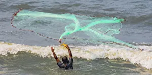A fisherman casting his net at Fort Kochi in Kerala, India A fisherman casting his net at Fort Kochi in Kerala, India