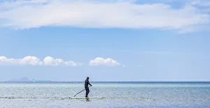 A paddleboarder at Orewa in Auckland Region, New Zealand A paddleboarder at Orewa in Auckland Region, New Zealand