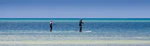 Two paddleboarders at Orewa in Auckland Region, New Zealand Two paddleboarders at Orewa in Auckland Region, New Zealand