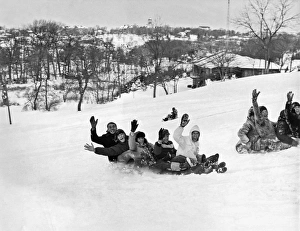 <b class=qtipBold><figcaption>A Backwards Toboggan Ride</figcaption></b><br>Pennsylvania: c. 1940 A group of adults wave as they ride backwards on a toboggan down Cedar Crest Hill.<br><em>© Underwood Archives/UIG</em> A Backwards Toboggan Ride