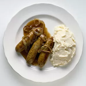 Gravy Collection: Bangers and mash with onion gravy on white plate