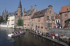 Belgium, Bruges, medieval houses line the River Dijver, with boat sailing along the river Belgium, Bruges, medieval houses line the River Dijver, with boat sailing along the river