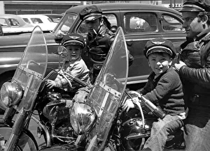 <b class=qtipBold><figcaption>Bikers And Their Sons</figcaption></b><br>San Francisco, California c. 1954 Two bikers wearing caps and leather jackets on their Harley Davidsons with their small sons in front of them. The boys are wearing caps that say 'Harley Davidson Motor Cycle'.<br><em>© Underwood Archives/UIG</em> Bikers And Their Sons