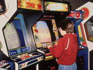 <b class=qtipBold><figcaption>Boy playing video arcade games</figcaption></b> Boy playing video arcade games