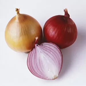 Whole brown onion, whole red onion and a red onion cut in half, close-up