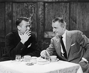 Businessmen smoking cigarettes and smiling Businessmen smoking cigarettes and smiling