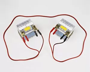 Two car batteries attached by jump leads