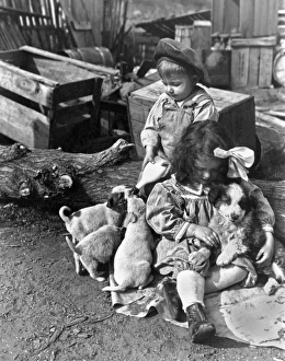 <b class=qtipBold><figcaption>Children On Farm With Puppies</figcaption></b><br>United States: c. 1910. A couple of farm kids take care of the new puppies, one feeding while the other one snuggles.<br><em>© Underwood Archives/UIG</em> Children On Farm With Puppies