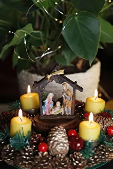 Christmas crib and natural advent wreath or crown with four burning yellow candles Christmas crib and natural advent wreath or crown with four burning yellow candles