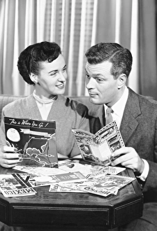 Couple with brochures deciding on vacation Couple with brochures deciding on vacation