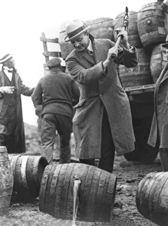 <b class=qtipBold><figcaption>Destroying Barrels Of Beer</figcaption></b><br>Philadelphia, Pennsylvania: December, 1924 Public Safety Director Smedley D. "Duckboards" Butler destroying barrels of beer with a pick axe during Prohibition and letting it run into the Schuylkill River.<br><em>© A</em> Destroying Barrels Of Beer