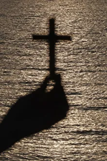 Faithful woman praying with chrisrtian cross at sunset. Close-up onn hand Faithful woman praying with chrisrtian cross at sunset. Close-up onn hand