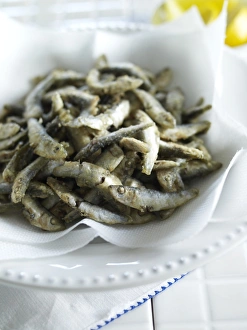 Fried whitebait on kitchen paper in bowl, close-up Fried whitebait on kitchen paper in bowl, close-up