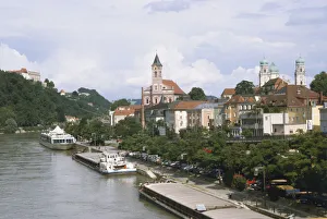 Germany, Bavaria, the beautiful town of Passau, on the river Danube. The river is lined with industrial barges, a passenger boat, with the onion domes of Dom St Stephen in the background Germany, Bavaria, the beautiful town of Passau, on the river Danube. The river is lined with industrial barges, a passenger boat, with the onion domes of Dom St Stephen in the background