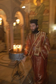 Greek orthodox priest in the Holy Sepulcher basilica in Jerusalem Greek orthodox priest in the Holy Sepulcher basilica in Jerusalem