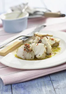 Grilled monkfish with spicy vinaigrette, on white plate Grilled monkfish with spicy vinaigrette, on white plate