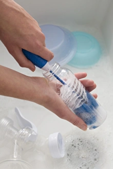 Hand scrubbing inside of baby bottle with a bottle brush, close-up Hand scrubbing inside of baby bottle with a bottle brush, close-up