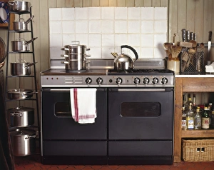 Kitchen oven and hob unit with stainless steel kettle and steamer on top, pan shelving Kitchen oven and hob unit with stainless steel kettle and steamer on top, pan shelving