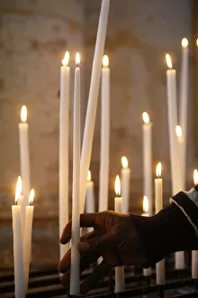 Man praying with candles in church Man praying with candles in church