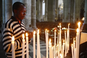 Man praying with candles in church Man praying with candles in church