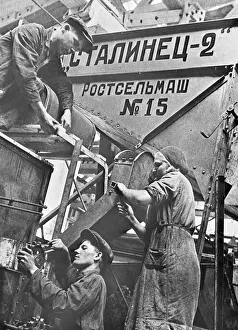 Men and women at work on a combine harvester in a factory at Rostov-on-Don, Union Men and women at work on a combine harvester in a factory at Rostov-on-Don, Union