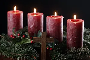 Natural advent wreath or crown with four burning red candles and christian cross Natural advent wreath or crown with four burning red candles and christian cross
