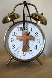 Old-fashioned vintage copper alarm clock with christian cross Old-fashioned vintage copper alarm clock with christian cross