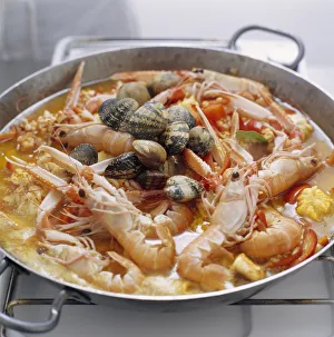 Paella cooking in pan on gas hob Paella cooking in pan on gas hob