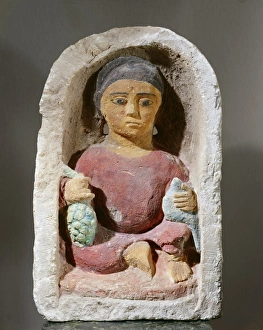 Legs Crossed At Knee Gallery: Painted limestone funerary stele representing Isis with a dove and a bunch of grapes
