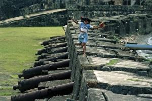 Panama, Colon Province, Portobelo, girl walking on fortification ruins by cannons Panama, Colon Province, Portobelo, girl walking on fortification ruins by cannons