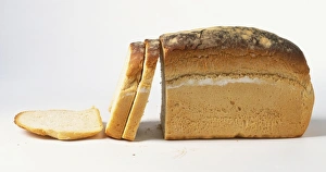 Partially sliced loaf of white bread, side view Partially sliced loaf of white bread, side view