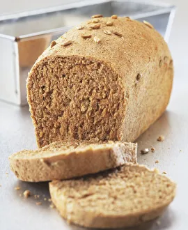Partially sliced loaf of wholemeal bread, close up Partially sliced loaf of wholemeal bread, close up