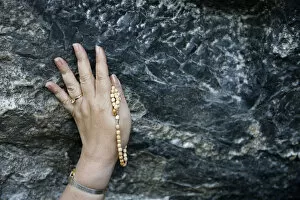 Images Dated 20th April 2000: Pilgrim touching the Lourdes grotto